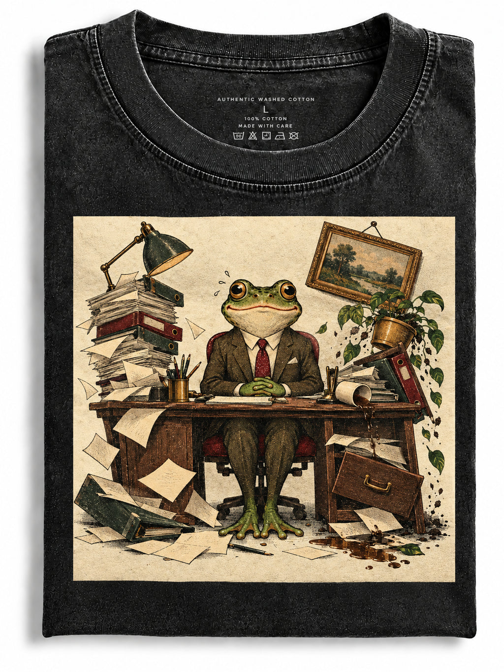 Folded black t-shirt printed with a frog in a suit sitting at a messy office desk