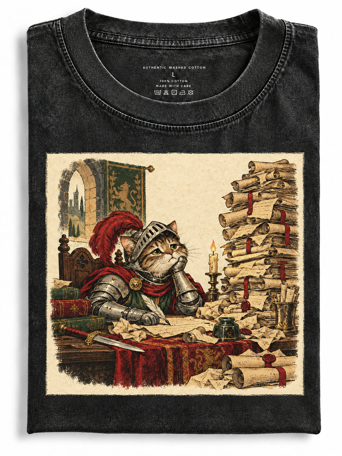 Washed black folded t-shirt featuring an armored knight cat sitting at a desk surrounded by scrolls