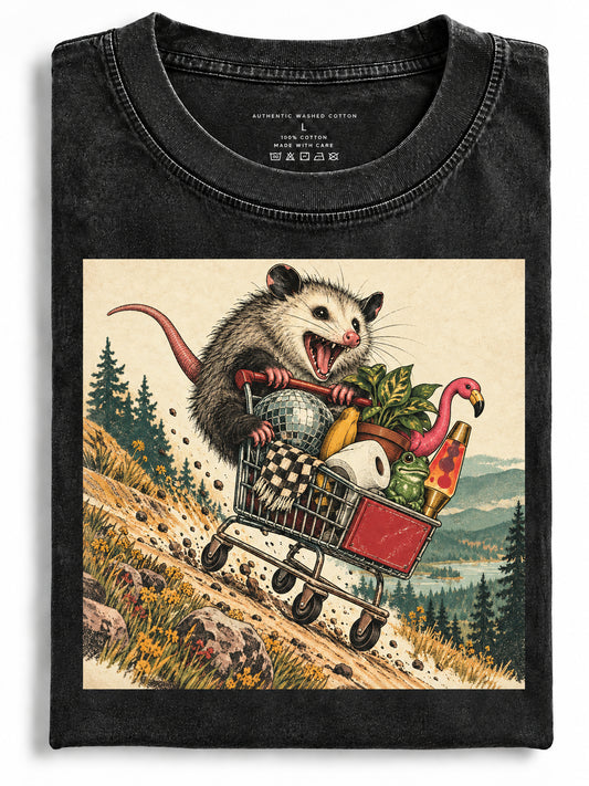 Folded black t-shirt featuring an opossum riding a shopping cart downhill